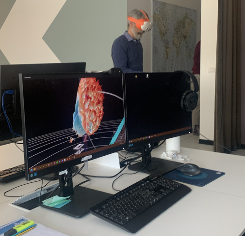 a man wearing a mask and standing in front of two monitors Realtà Virtuale per l'astrofisica